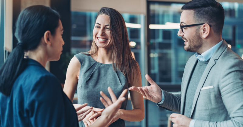 Trois personnes discutant lors d'un événement professionnel